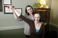 photo of female doctor holding up arm of female patient